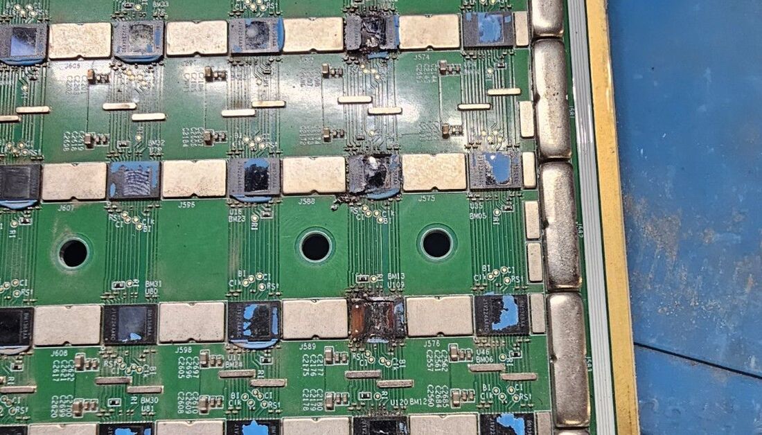 Failed ASIC hashboard as received, with a burnt power-stage component visible