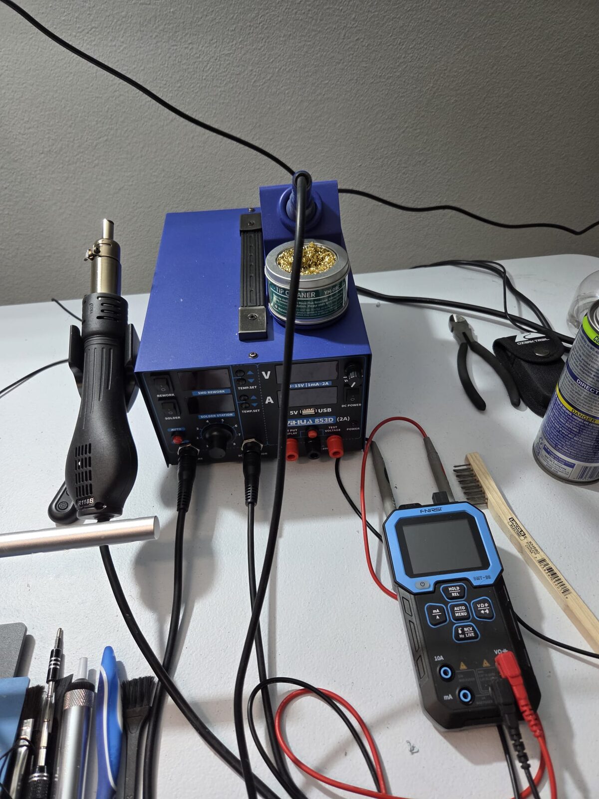 ASIC repair workbench with SMD rework station, hot-air gun, and multimeter at the Astro Solutions Odessa lab